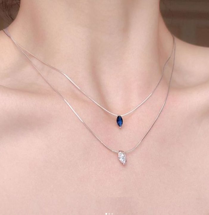 Minimalist silver necklaces layered on a jewelry tray