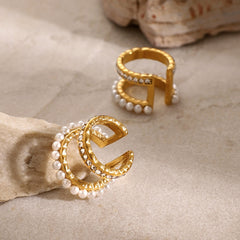 Close-up of 18K gold pearl and diamond earrings reflecting light luxury style