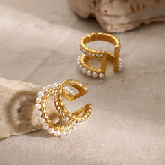 Close-up of 18K gold pearl and diamond earrings reflecting light luxury style
