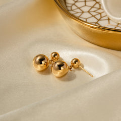 Orla 18K gold round ball stud earrings on a neutral background