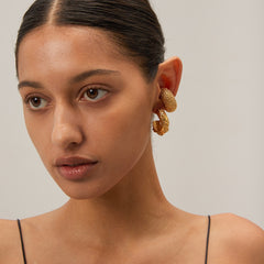 Model wearing Lunaria textured C-hoop earrings with sleek pulled-back hair