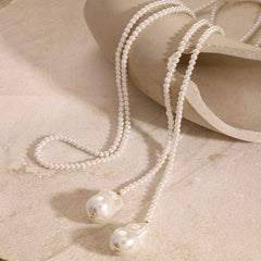 Close-up of large irregular pearl on gold beaded pearl necklace