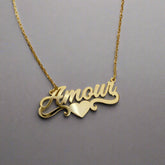 Custom silver heart name necklace displayed on white fabric background