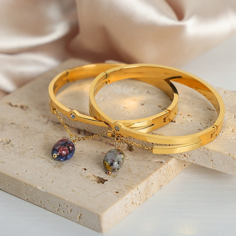 Lunaria 18K gold bracelet with V-shaped chain and gemstone pendant on white background