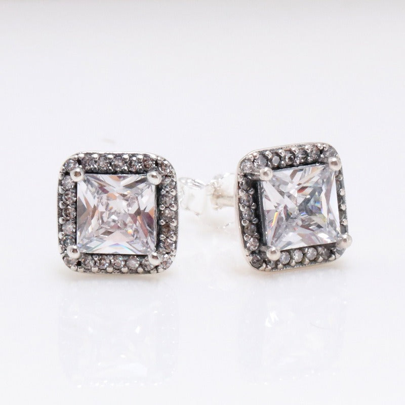 Aurea square diamond earrings in S925 silver with halo design on display stand