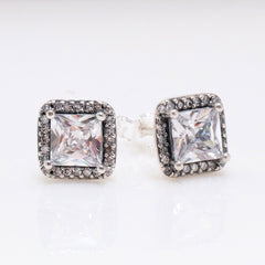 Aurea square diamond earrings in S925 silver with halo design on display stand
