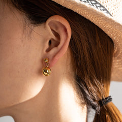 Model wearing Orla minimalist ball earrings with slick hair and neutral makeup