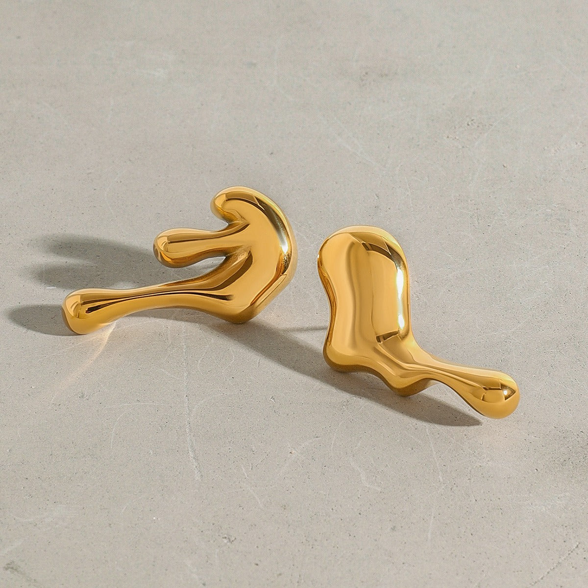 Close-up of 18K gold lava-shaped earrings with flowing contours