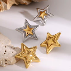 Close-up of 18K gold concave-convex star earrings on white background