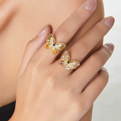 Woman’s hand wearing butterfly diamond ring in soft daylight