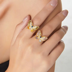 Woman’s hand wearing butterfly diamond ring in soft daylight