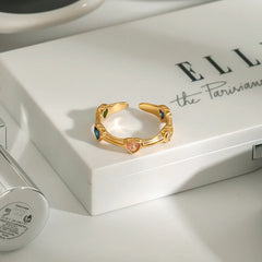 Adjustable gold ring with gemstone-encrusted heart motifs
