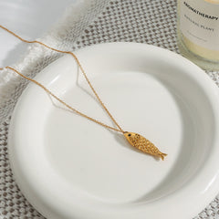 Gold necklace with fish pendant and delicate pearl details