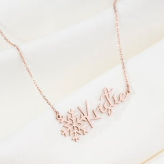 Close-up of engraved name on silver snowflake pendant necklace