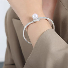 Close-up of twisted design with pearl inlay on gold cuff bracelet