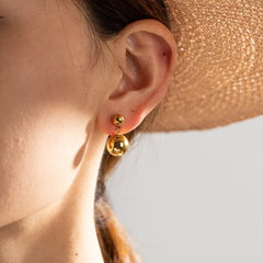 Model wearing Orla minimalist ball earrings with slick hair and neutral makeup