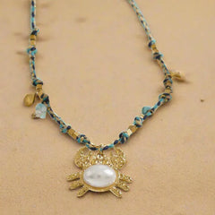 Ocean-inspired gold necklace with crab, shell, and starfish