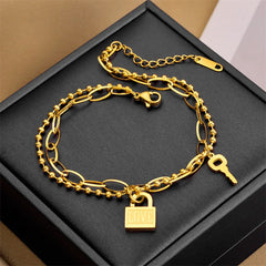 Close-up of 18K gold minimalist bracelet with heart lock charm