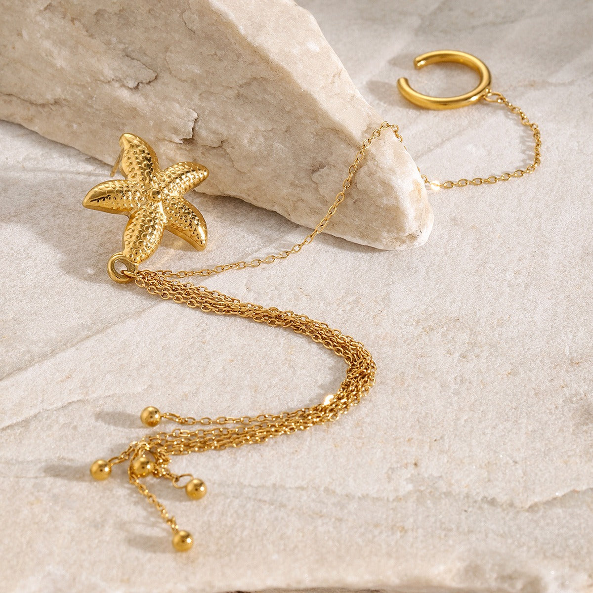 Mirella 18K gold starfish earrings with flowing tassel design on white background
