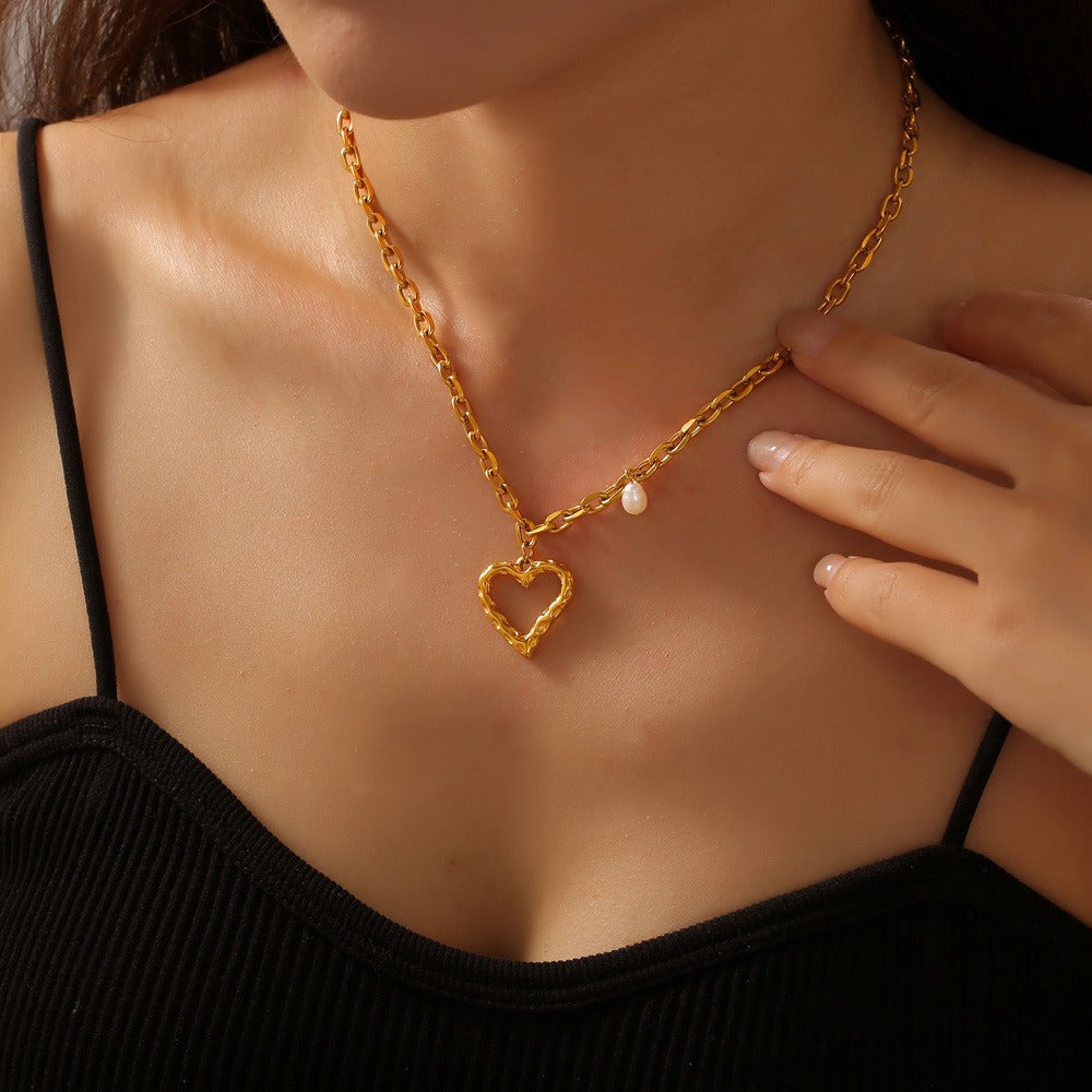 Model wearing delicate heart-shaped gold necklace with neckline focus