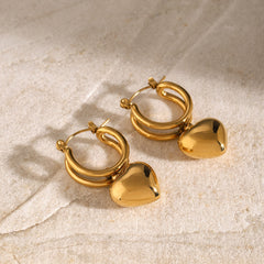 Vivara 18K gold earrings with sliding heart feature on white background
