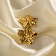 Close-up of vintage floral stud earrings with polished gold finish