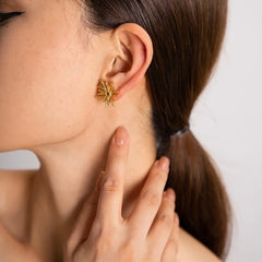 Model wearing Solara earrings styled with soft curls and linen blouse