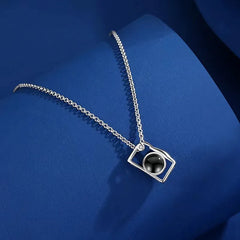 Titanium steel camera necklace on retro backdrop with photography props