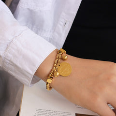 Vintage-style gold coin charm on beaded bracelet