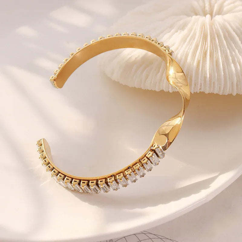 Twisted gemstone bracelet displayed on white marble or neutral background