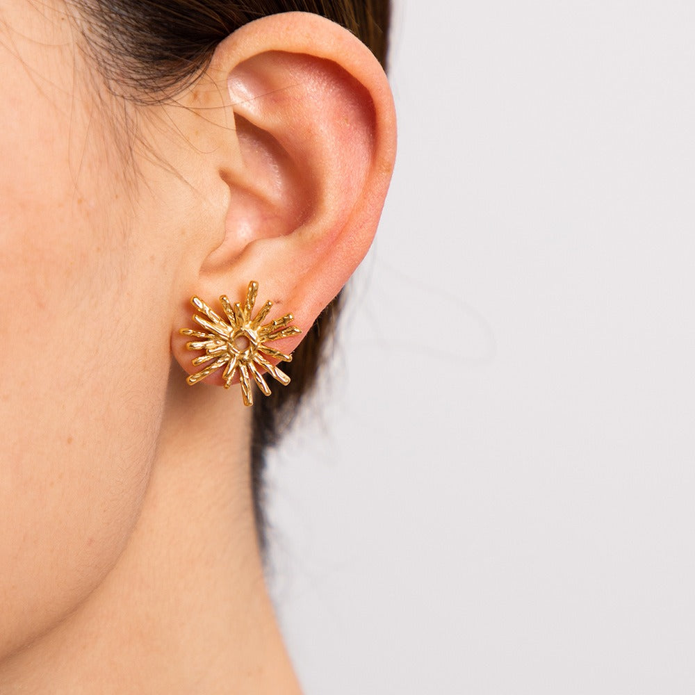 Model wearing Solara earrings styled with soft curls and linen blouse