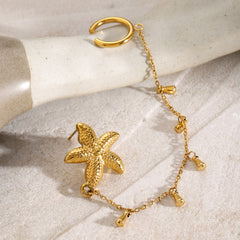 Side view of sculptural gold starfish earrings reflecting summer light
