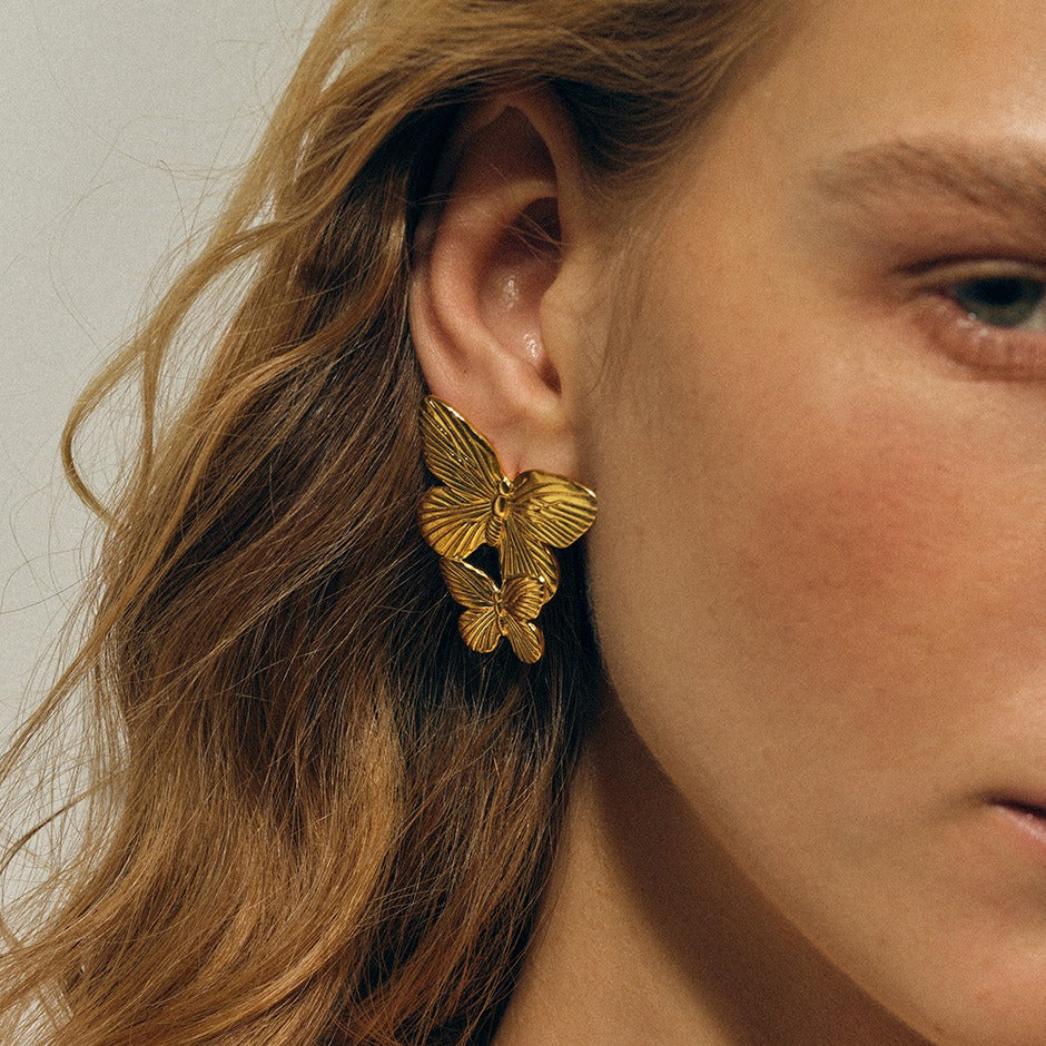 Hand-textured gold surface on butterfly silhouette earrings