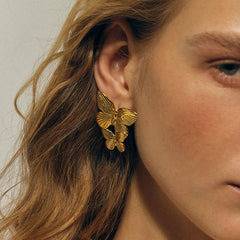 Hand-textured gold surface on butterfly silhouette earrings