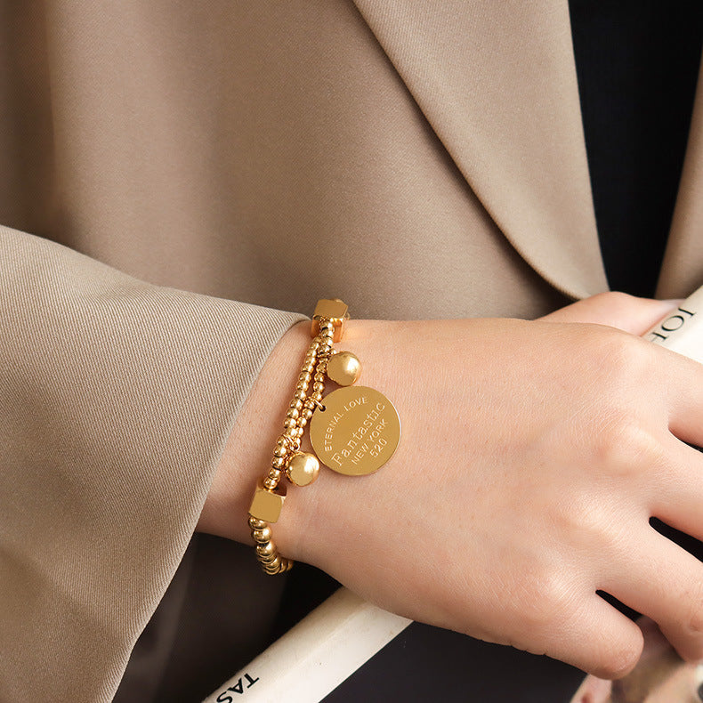 Minimalist 18K gold bracelet with ball beads and medallion design