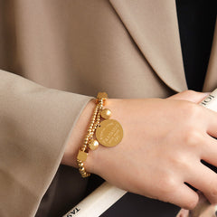 Minimalist 18K gold bracelet with ball beads and medallion design