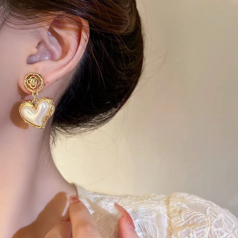 Elegant pearl heart earrings styled for romantic occasions