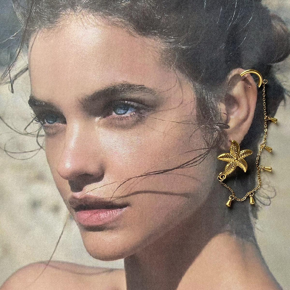 Model wearing Marina starfish earrings with beachy waves and sun hat
