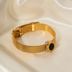 Black gemstone and engraved Roman numerals on vintage-style gold bracelet