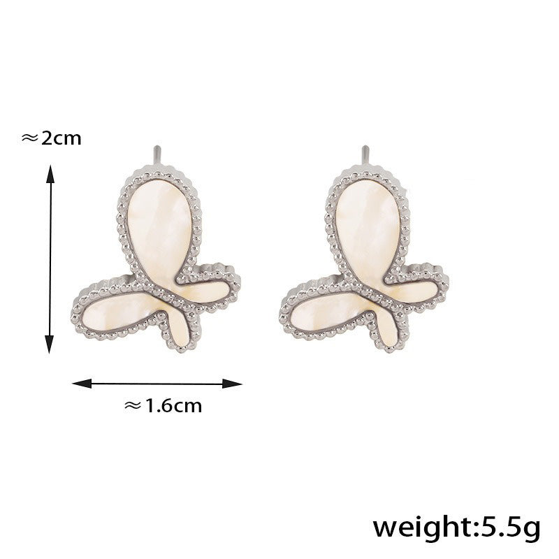 Flat lay of Celestia Flare 18K gold butterfly earrings
