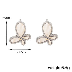 Flat lay of Celestia Flare 18K gold butterfly earrings