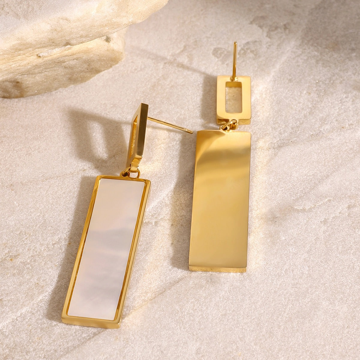 Gemstone detail set in polished rectangular gold pendant earrings