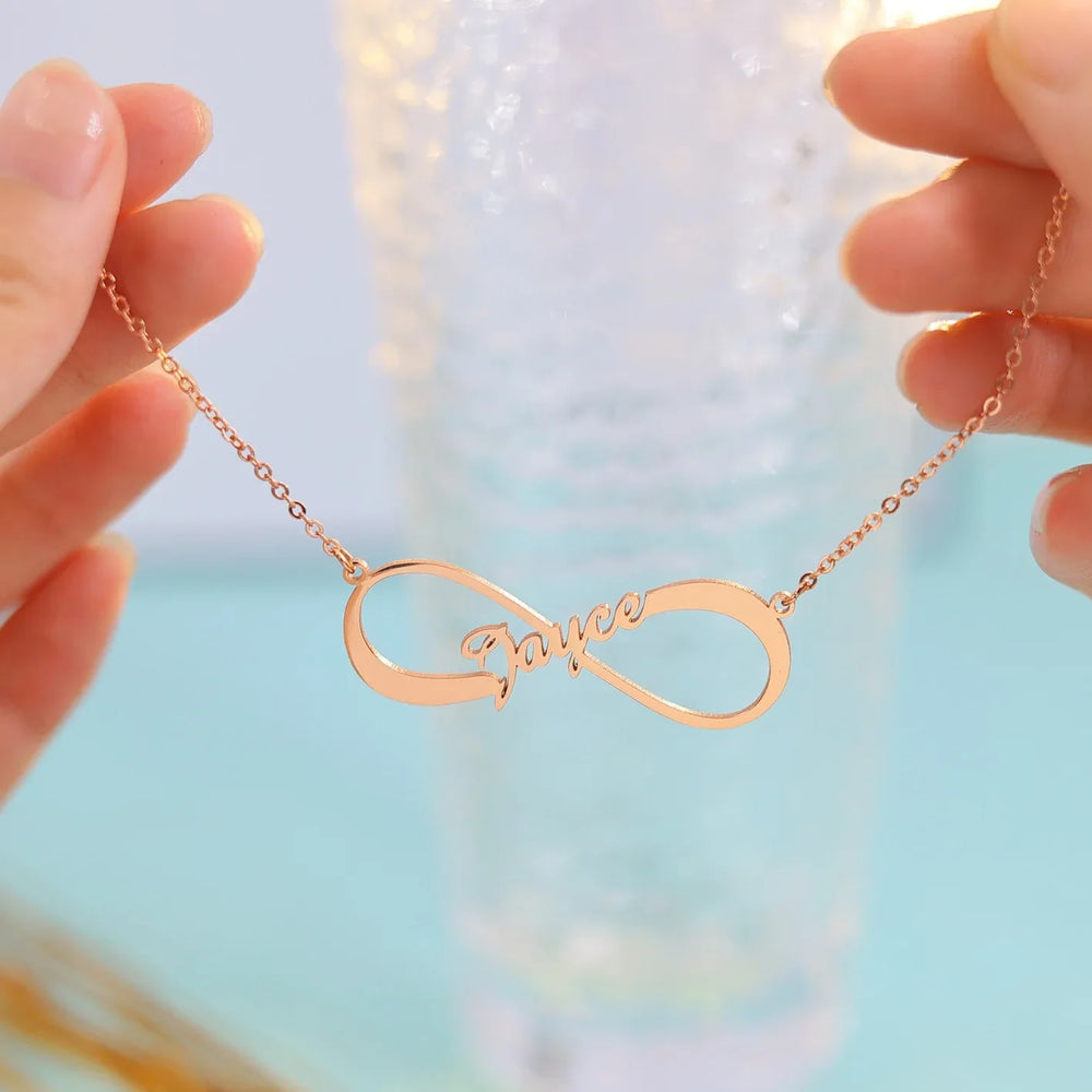 Close-up of personalized silver infinity pendant with engraved name