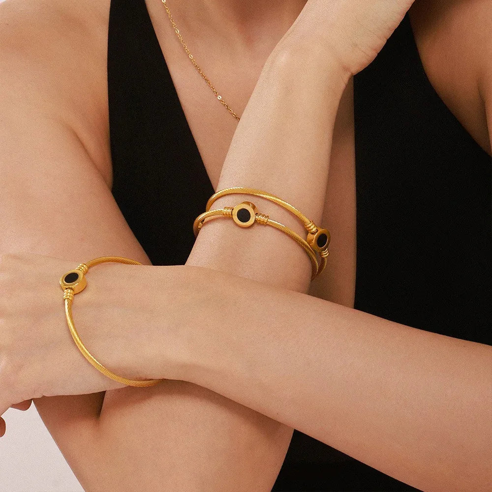 Elegant gold bracelet with twill texture and gemstone center