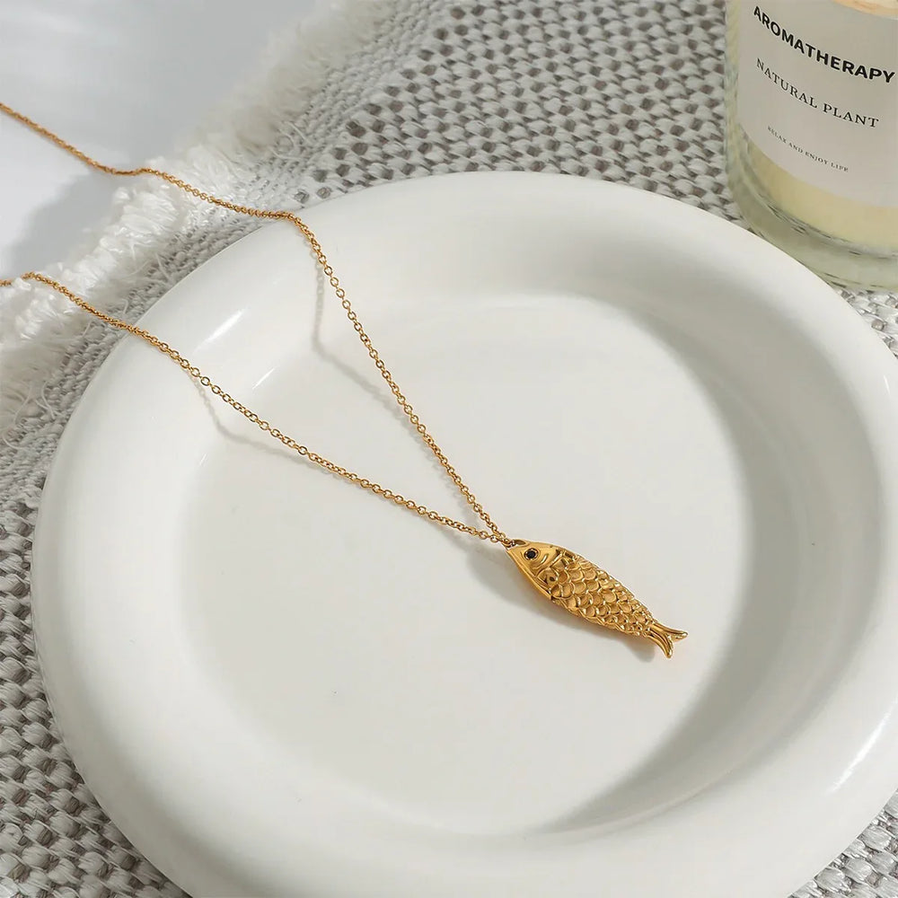 Gold necklace with fish pendant and delicate pearl details