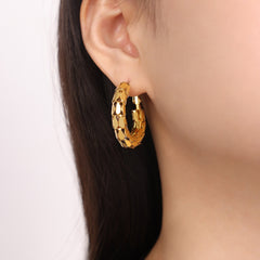 "Woman wearing C-shaped gold earrings styled with business attire