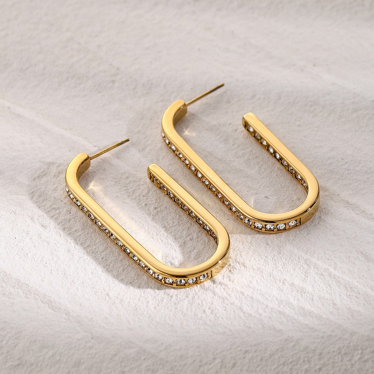 Detailed view of diamond-studded U-shaped gold earrings