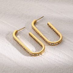 Detailed view of diamond-studded U-shaped gold earrings
