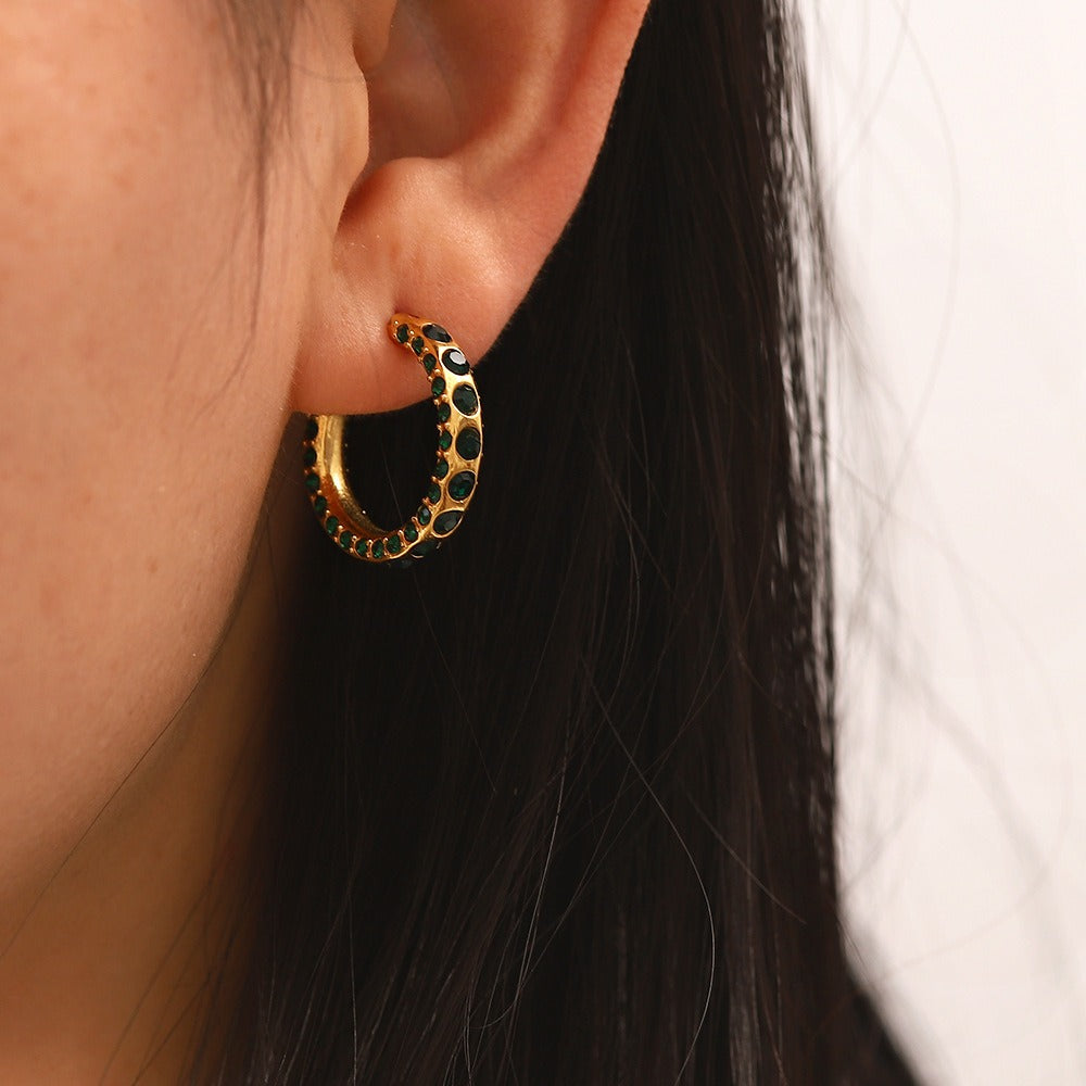 Detail of hand-set diamonds around 18K gold circular earrings