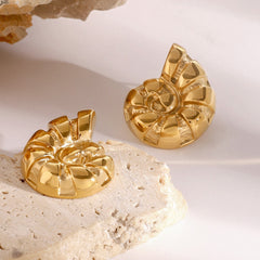 Spiral texture detail on gold conch-shaped earrings